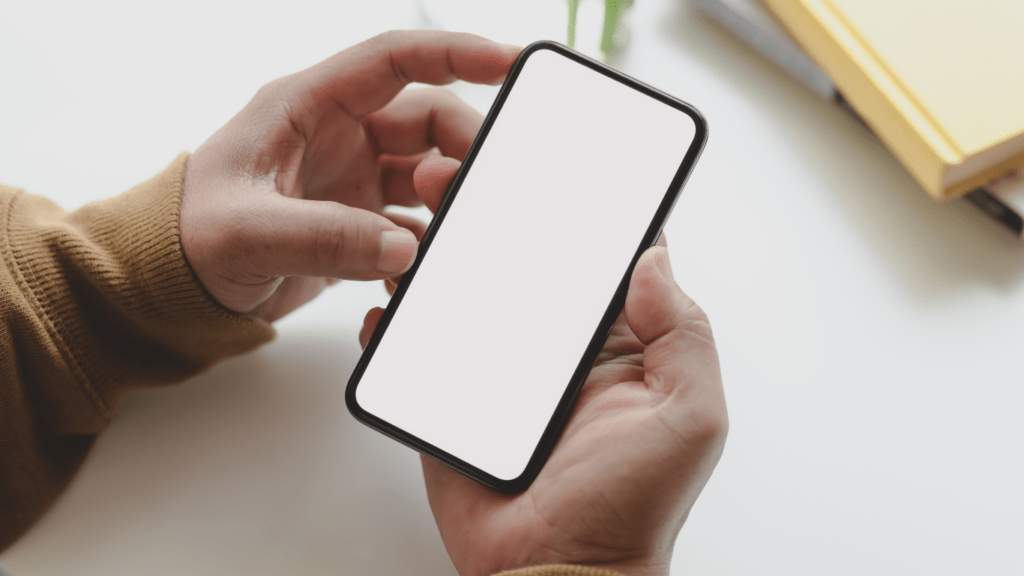 a person is using a smartphone with a blank white screen