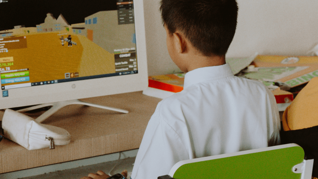 a child sitting at a desk in front of a computer