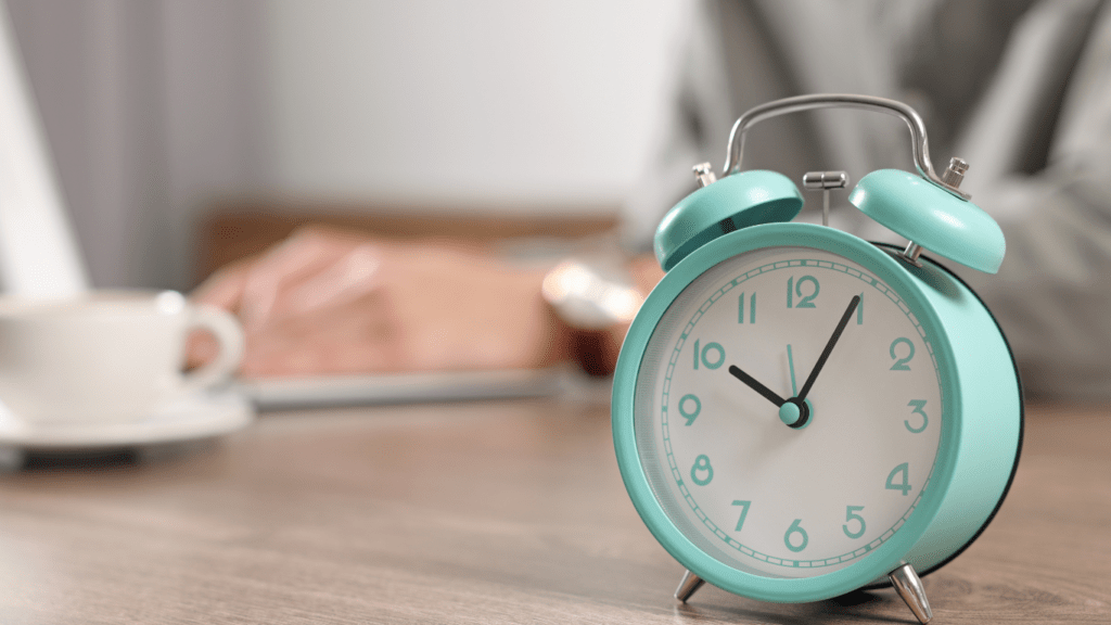 a clock and glasses sitting on a desk