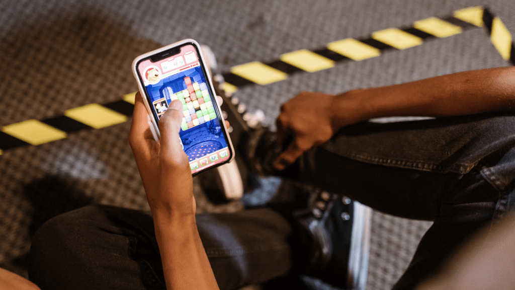 a person holding up a smartphone with a video game on it