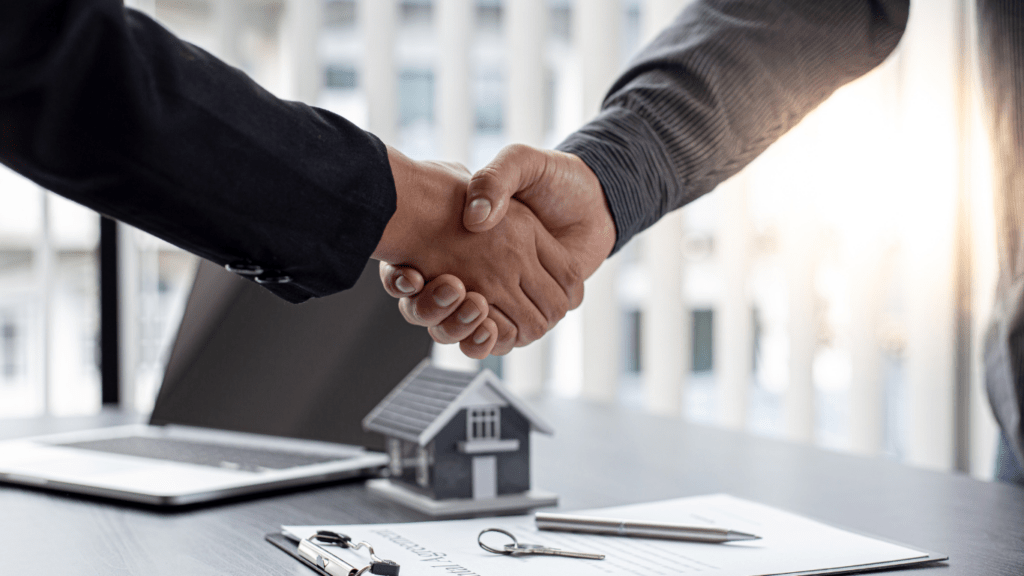 two business people shaking hands over a laptop